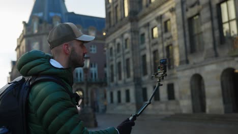 Young-adult-man-standing-and-talking-to-action-camera,-recording-video-of-self
