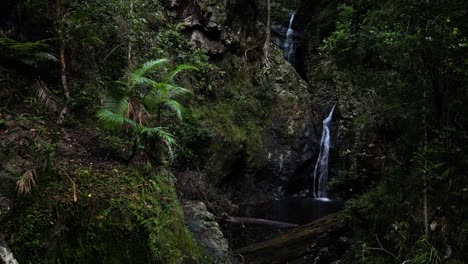 Water-cascading-down-moss-covered-waterfall-rock-pools-hidden-deep-in-a-tropical-jungle-oasis