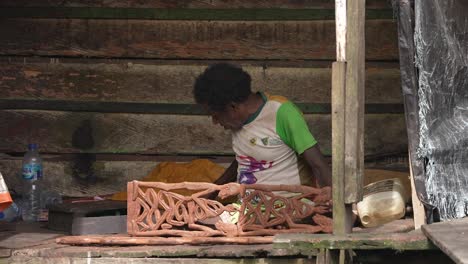 The-old-man-is-working-on-making-typical-Asmat-wood-carvings-that-are-sought-after-by-many-collectors