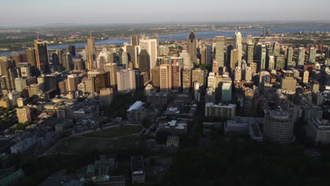 Aerial-tracking-shot-in-front-of-downtown-Montreal,-summer-sunset-in-Canada