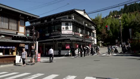 Locals-and-tourists-passing-by-an-intersection-in-Takayama,-Gifu