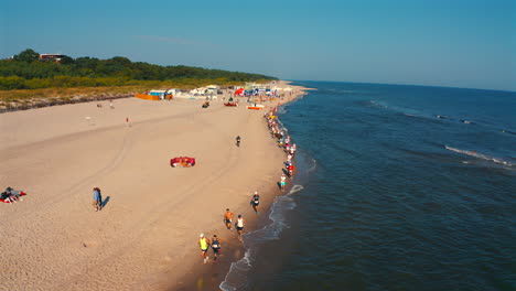 People-running-marathon-on-the-beach-in-Jastarnia,-Poland