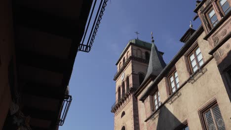 Historic-church-tower-and-building-in-Kaysersberg,-France-on-clear-sunny-day
