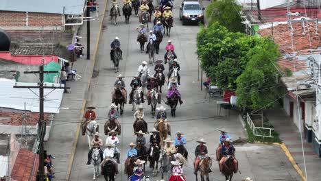 Aerial-view-of-Inagural-parade-on-Mariachi-Festival-in-Tecalitlan,-Mexico---Mexican-equestrian-Riding-Horses-on-street