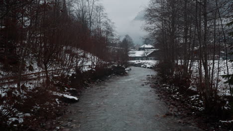 Serene-view-of-the-Weisse-Lütschine-river-in-Lauterbrunnen,-Switzerland,-captured-on-a-tranquil,-snowy-winter-day,-showcasing-the-ethereal-beauty-of-nature
