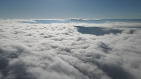 Drone-view-through-cloudy-sky,-white-puffy-sky