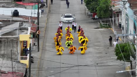 Vista-Aérea-Que-Muestra-A-Una-Mujer-Disfrazada-Bailando-En-La-Calle-En-El-Festival-De-Mariachi-En-Tecalitlán,-México