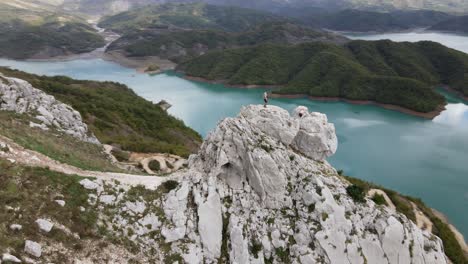 Panoramic-aerial-view-of-a-man-rock-climbing-hills-at-Bovilla-reservoir-overlooking-Bovilla-Lake,-Albania,-Europe
