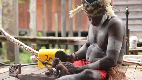 Spielende-Teenager-Und-Alte-Männer,-Die-Holzstatuen-Papuanischer-Asmat-Schnitzen
