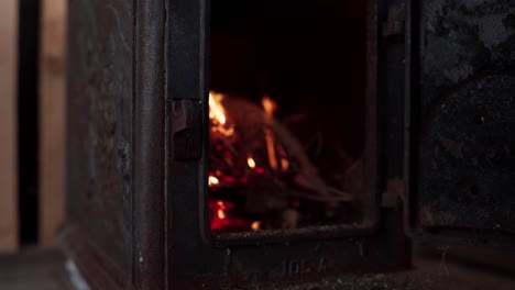 A-Man's-Hand-is-Igniting-a-Fire-in-the-Wood-Stove-in-Indre-Fosen,-Trondelag-County,-Norway---Close-Up