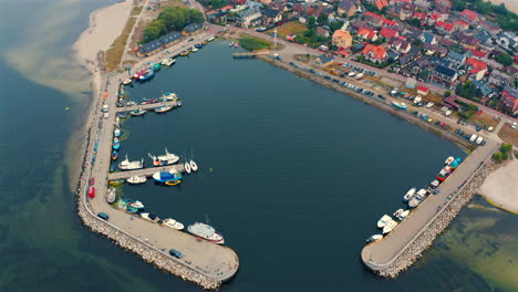 Aerial-view-of-small-marina-in-Kuznica,-Poland-with-moored-yachts-and-fishing-boats
