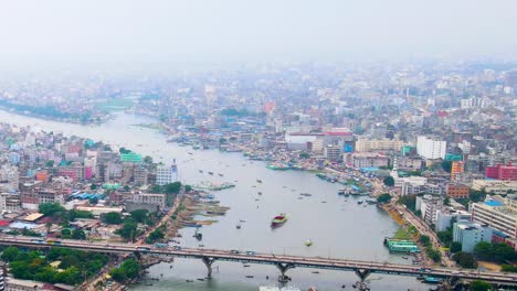 Dhaka-cityscape-and-Burigana-river-port,-ship-terminal,-aerial-view