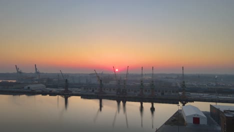 Werftkräne-Während-Eines-Sonnenaufgangs,-Luftaufnahme-Der-Stadt-Stettin
