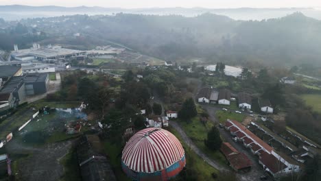 Drone-descends-misty-clouds-to-striped-circus-tent-of-Benposta-in-Spain