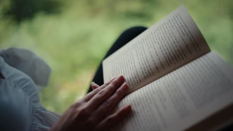 Closeup-shot-of-book-while-woman-turning-pages-in-a-cabin