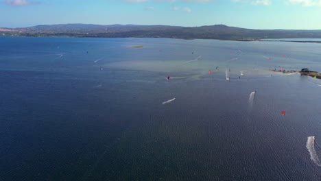 Panoramic-drone-shot-of-Kite-surfing-competition-at-Punta-Trettu,-San-Giovanni-Suergiu,-South-Sardinia,-Italy