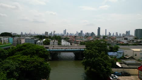 Ascending-Aerial-view-of-Bangkok-City-Canals-with-Thailand-Skyline-in-Background