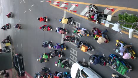 Thai-traffic-style,-motorcycle-waiting-for-the-green-light,-view-from-above,-vertical-footage