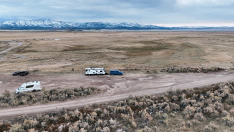 Motorhome-Trailers-Over-Remote-Plains-Camping-Ground-In-Utah,-United-States