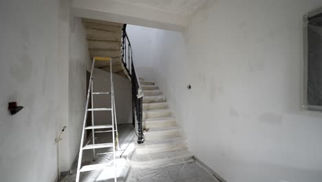 Escalera-De-Caracol-En-Casa-Cubierta-Con-Tela-De-Pintor-Para-Renovar,-Plataforma-Rodante-Estable-En-Toma