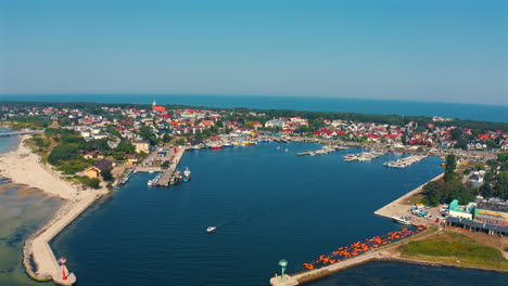 Drone-flying-towards-the-marina-in-the-city-of-Jastarnia-in-Poland-with-baltic-sea-in-the-background