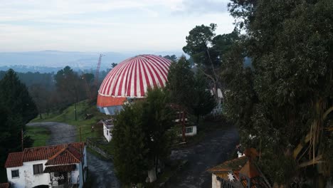Benposta-circus-tent-revealed-behind-trees-in-hillside-of-Ourense