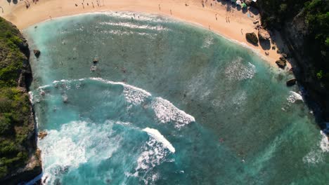 Foamy-Ocean-Waves-Rolling-Over-Sand-Atuh-Beach-in-Nusa-Penida,-Bali,-Indonesia---Aerial-Top-Down-Flyover