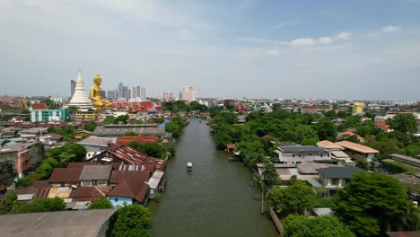 Chao-Phraya-River-Boat-Tour-Cruising-in-Phasi-Charoen-District-in-Bangkok,-Thailand---aerial-pull-back