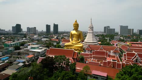 Golden-Buddha-Statue-Wat-Paknam-Bhasicharoen-in-Phasi-Charoen-Old-District-in-Bangkok,-Thailand---aerial-parallax