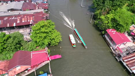 Tour-Boats-Cruising-on-Chao-Phraya-River-canal-in-Bangkok,-Thailand---Aerial-pan-up