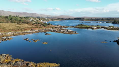 Aerial-drone-track-over-the-shoreline-of-a-rural-rocky-lake-landscape-in-Galway-Ireland
