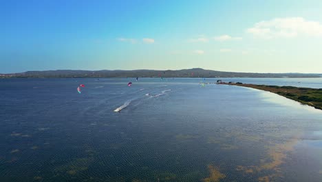 Panoramic-drone-shot-of-Kite-surfers-competition-at-Punta-Trettu,-San-Giovanni-Suergiu,-South-Sardinia,-Italy