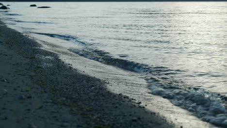 Intimate-waves:-Close-up-of-waves-breaking-on-a-serene-lake-shore-in-captivating-stock-footage