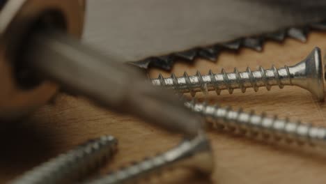 Beautiful-focus-rack-of-metal-screws-to-drill-bit-of-electronic-screwdriver-in-a-detailed-macro-shot