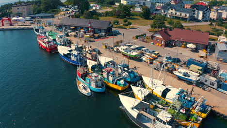 Drone-flying-over-fishing-boat-moored-in-the-marina-in-Jastarnia,-Poland-at-sunny-summer-day