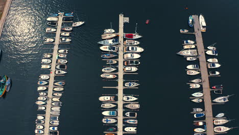 Drohnenansicht-Von-Oben-Mit-Blick-Auf-Luxuriöse-Yachten-Und-Motorboote,-Die-Im-Yachthafen-Festgemacht-Sind