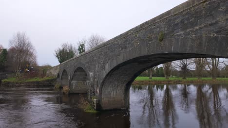 Río-Estático-Túmulo-Puente-Histórico-Sobre-El-Río-Con-Agua-Corriente-En-Athy-Kildare-Irlanda