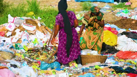 Arbeiterin-Sucht-Auf-Der-Mülldeponie-Nach-Nahrung-Und-Sortiert-Kleidung,-Lumpen-Und-Müllhaufen