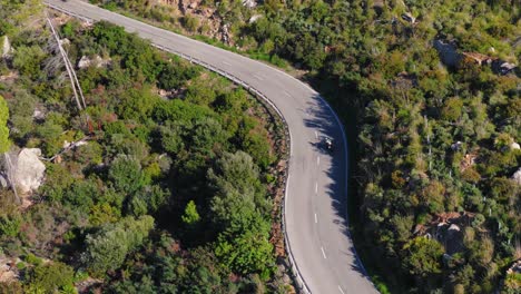 Camera-Follows-Motorcyclist-Riding-On-Serpentine-Road-In-Majorca-Mountains