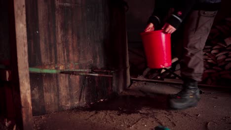 Man-Pours-Water-Onto-Steel-Bar-Before-Cutting-With-Angle-Grinder-Inside-The-Barn