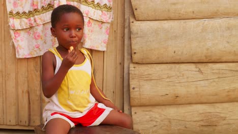Schwarzafrikanische-Kinder-Essen-Süßigkeiten-In-Einem-Abgelegenen-Ländlichen-Dorf-Afrikas,-Während-Sie-Alleine-Im-Freien-Spielen.-Nahaufnahme-Eines-Schwarzen-Kindes