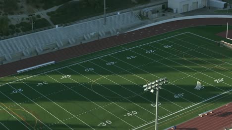 High-school-or-college-American-football-field---rising-aerial-tilt-down