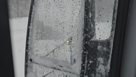 The-rearview-mirror-of-the-car-is-covered-with-wet-snow-during-the-storm
