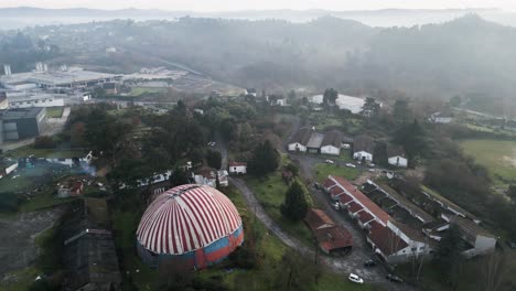 Drone-trucking-pan-to-reveal-settlement-homes-below-Benposta-circus-tent