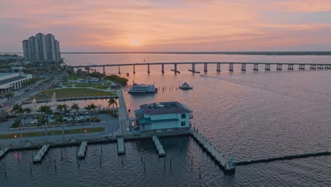 Aerial-view-of-Fort-Myers-Bridge-over-the-ocean-with-sunset-sky-in-Florida,-USA