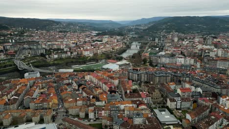 Aerial-establishing-shot-of-Ourense-bridges-crossing-river-in-middle-of-town