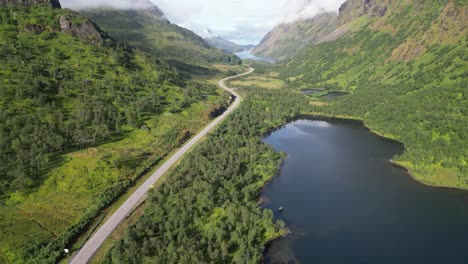 Malerische-Straße-Durch-Den-Fjord-In-Grindoya,-Lofoten,-Norwegen-–-4K-Luftaufnahme-Zeigt-Das-Kippen-Nach-Oben