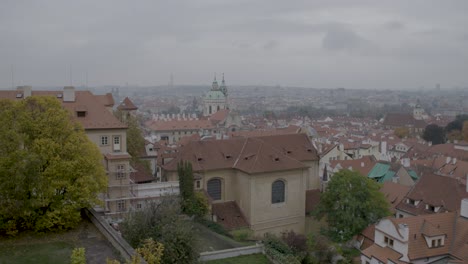 Panning-shot-of-Prague's-historic-buildings-with-orange-roofs-under-a-cloudy-sky