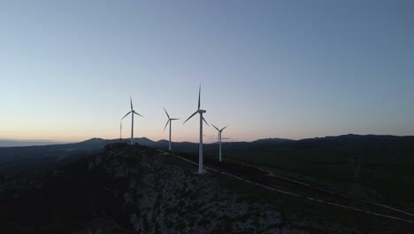 Serene-mountainous-landscape-with-wind-turbines-at-sunset