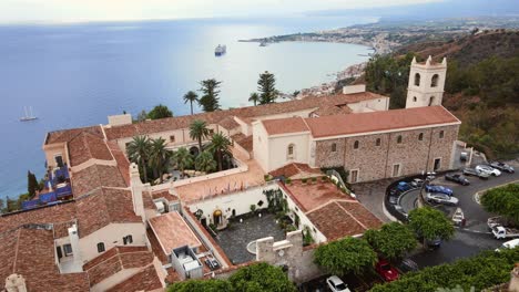 Drone-Orbitando-Alrededor-Del-Hotel-San-Domenico-En-Taormina-Mientras-El-Mar-Azul-Es-Visible-Al-Fondo